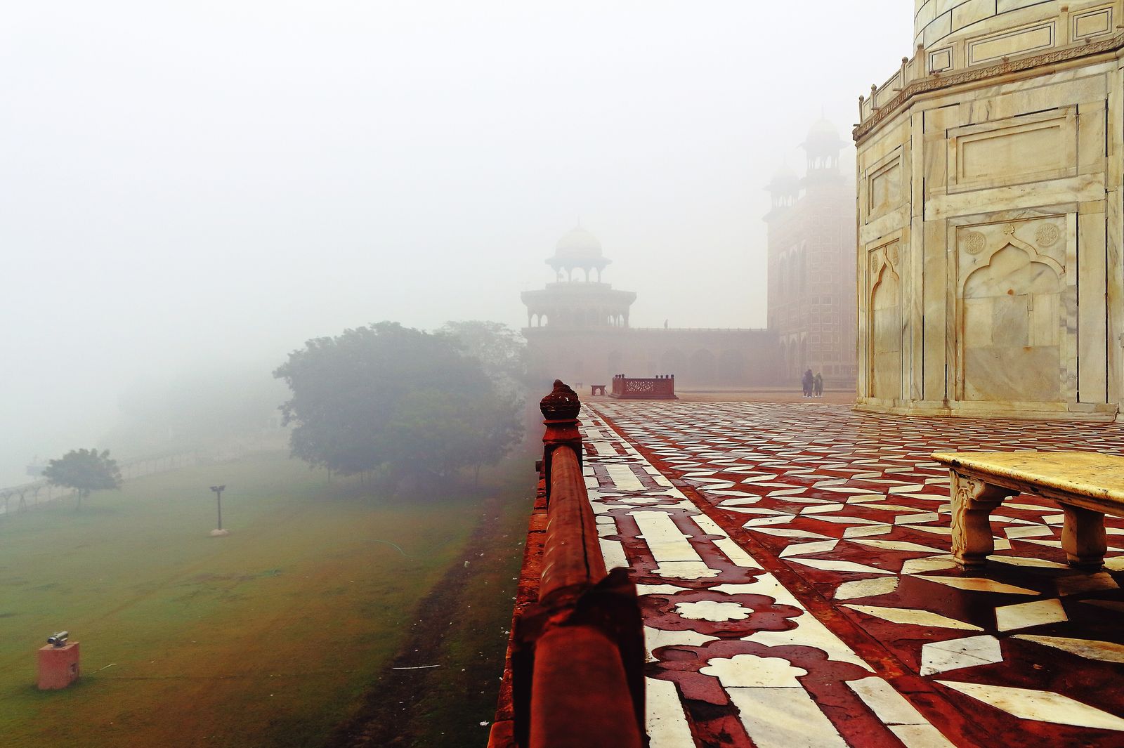 The Taj Mahal emerging from soft winter mist across its garden in the early morning