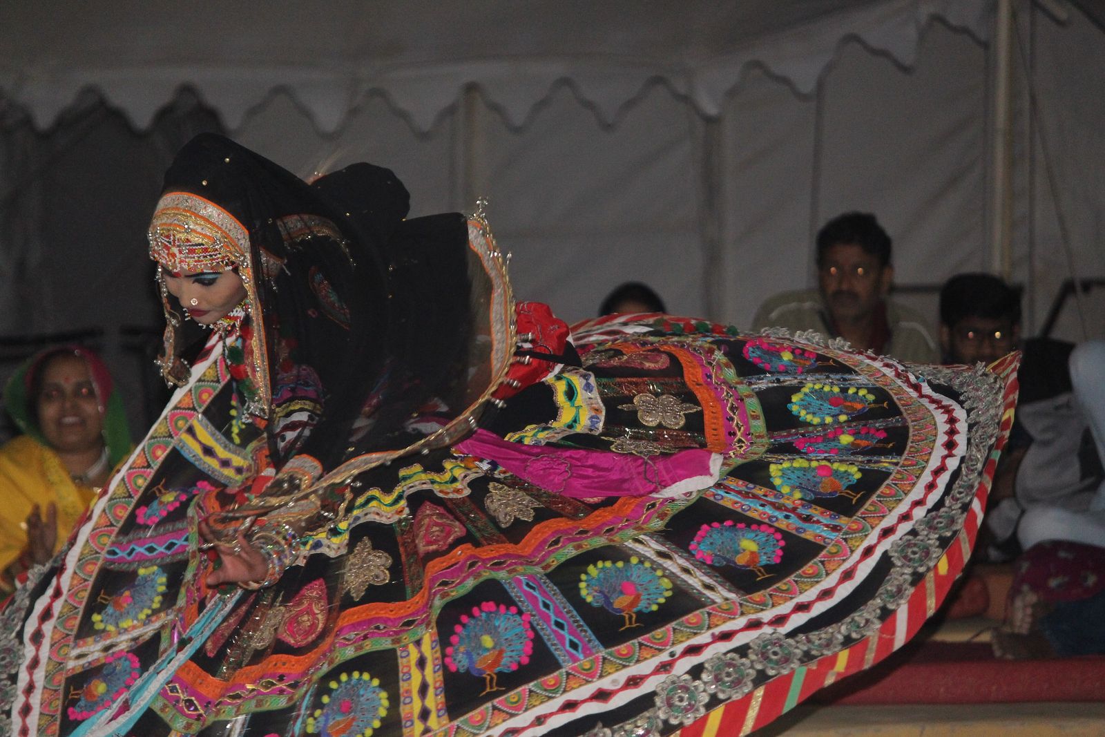 A Rajasthani folk dancer in a swirling embroidered skirt at an evening performance