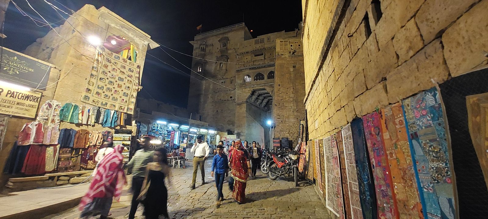 The walls and bastions of Jaisalmer Fort lit up gold against the night sky