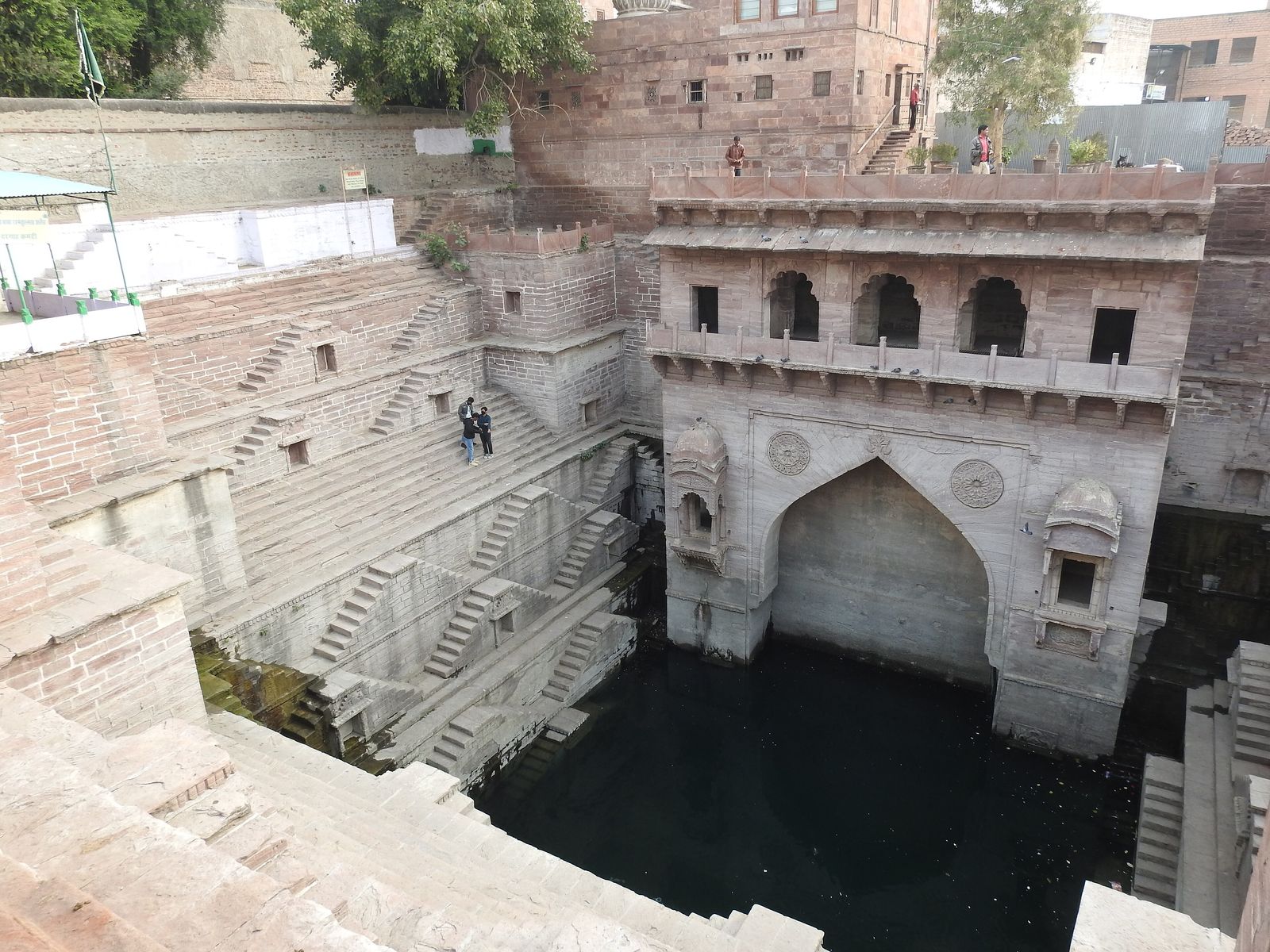The rose-red sandstone steps of Toorji ka Jhalra zigzagging down to green water in Jodhpur's old city