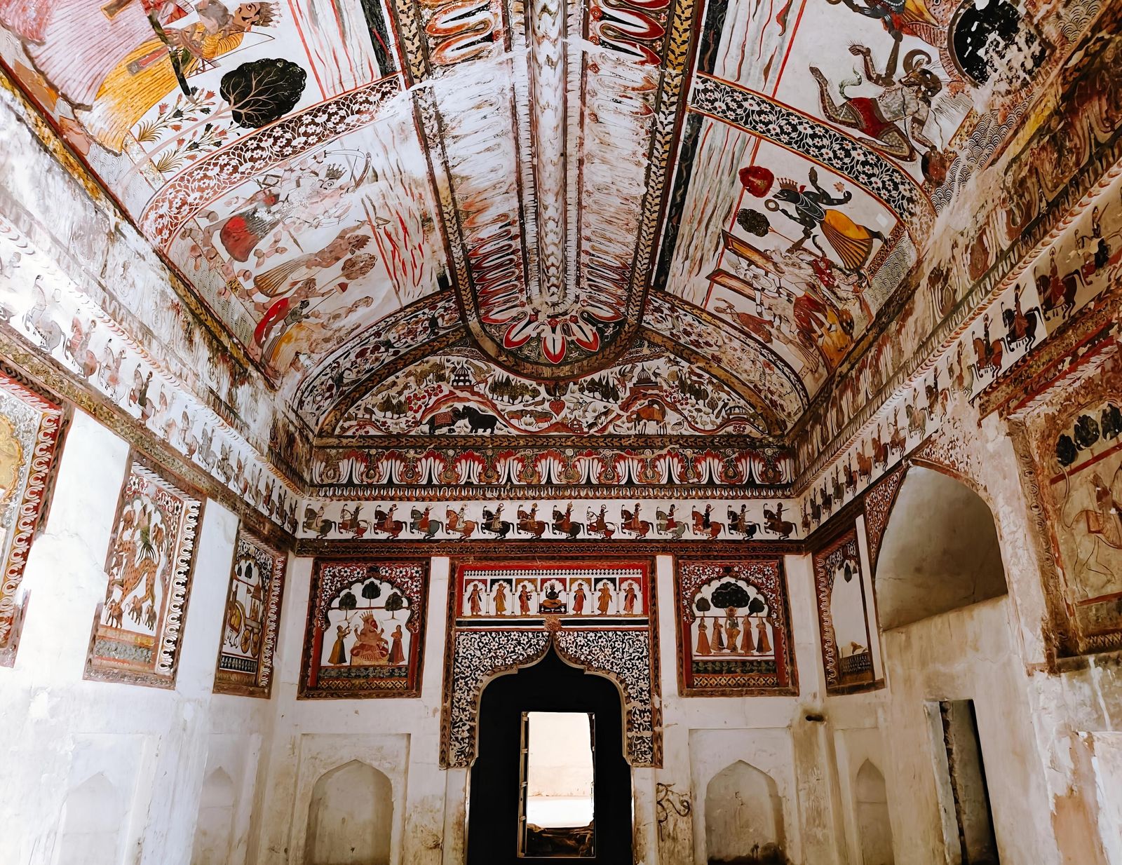 Painted scenes of gods and court life on the walls and ceiling of a royal chamber in the Raja Mahal at Orchha