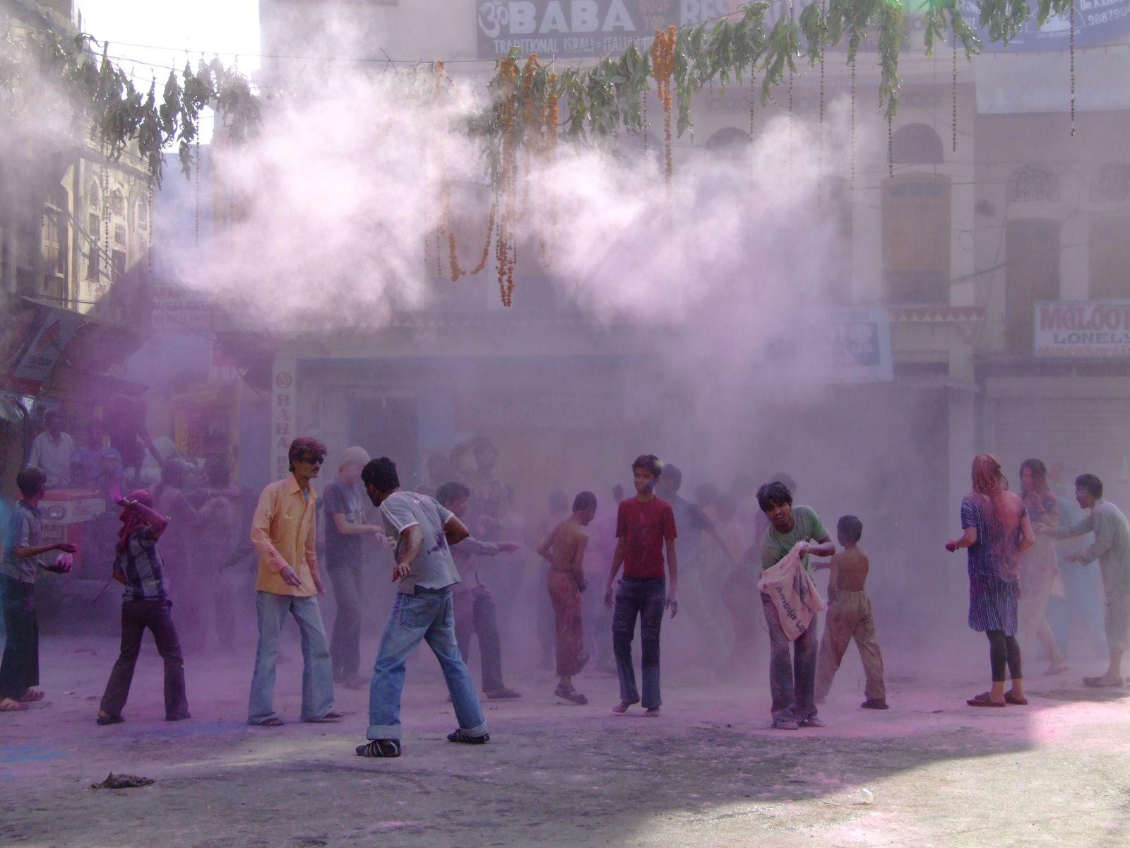 Revellers covered in coloured powder celebrating Holi in the streets of Pushkar