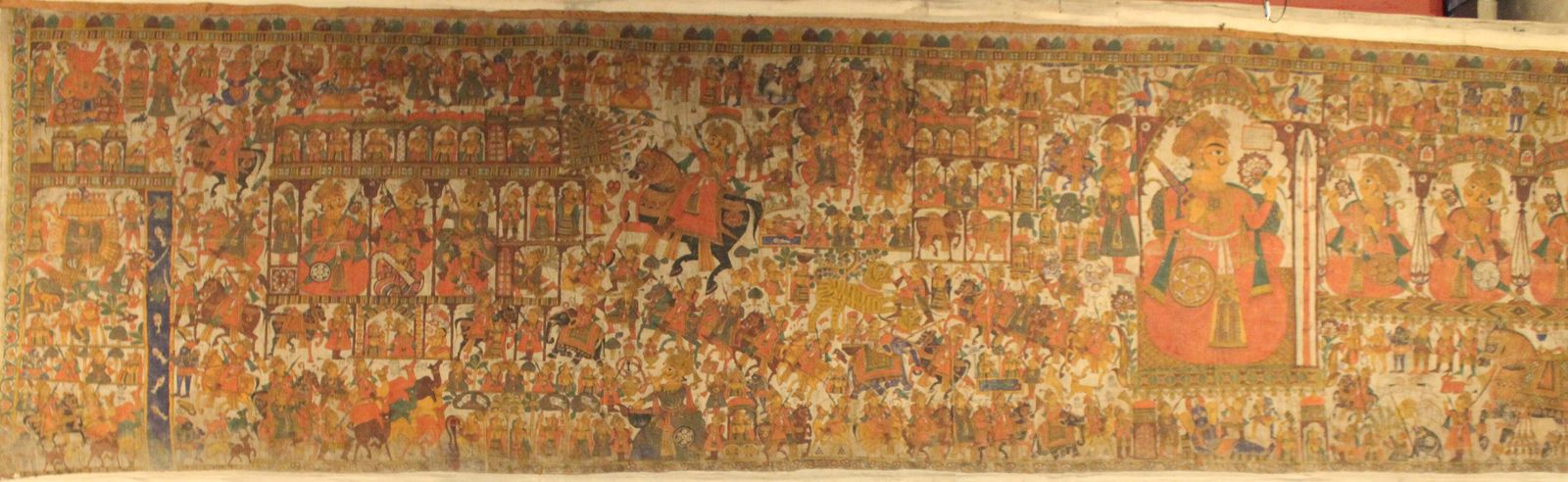 A long Rajasthani phad scroll painted with rows of figures, horses and battle scenes in red, yellow and green