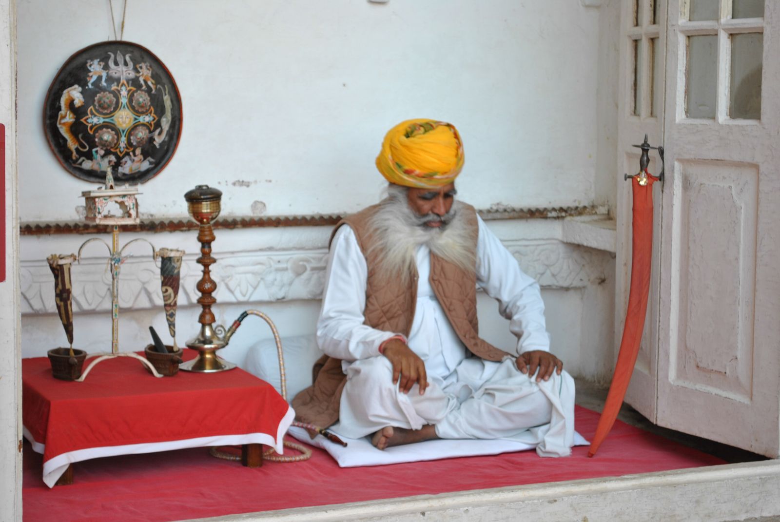 An older man in traditional Rajasthani dress and a large bright turban at Mehrangarh Fort Museum in Jodhpur