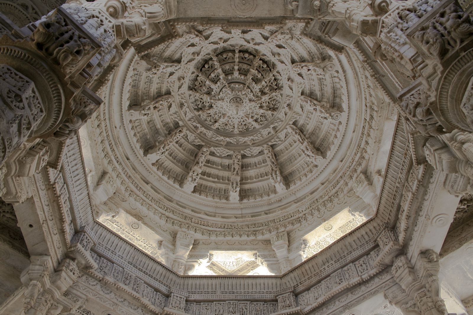 Looking up into a carved marble dome with a hanging central pendant at Ranakpur