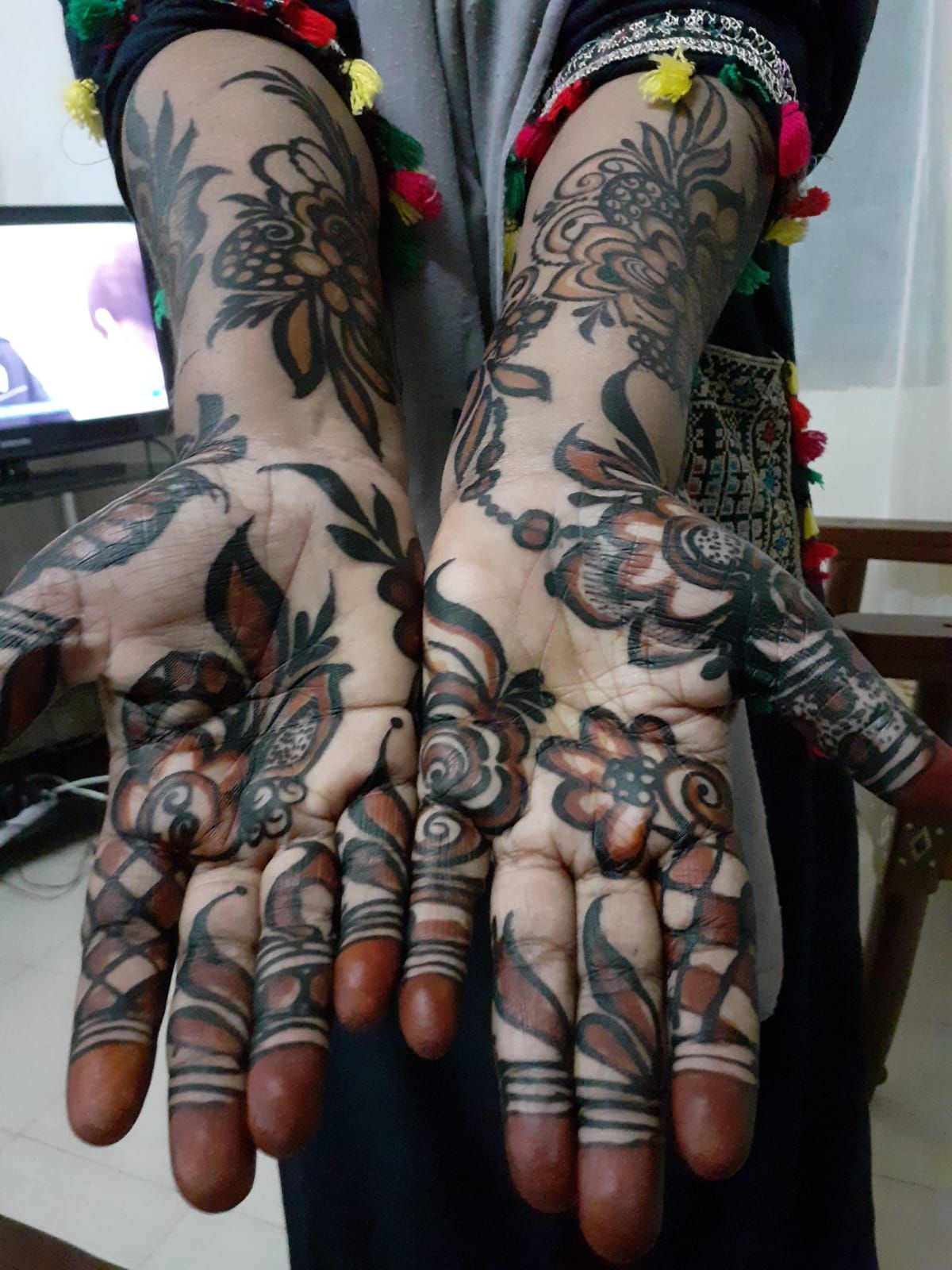Hands painted with fine, dark henna designs