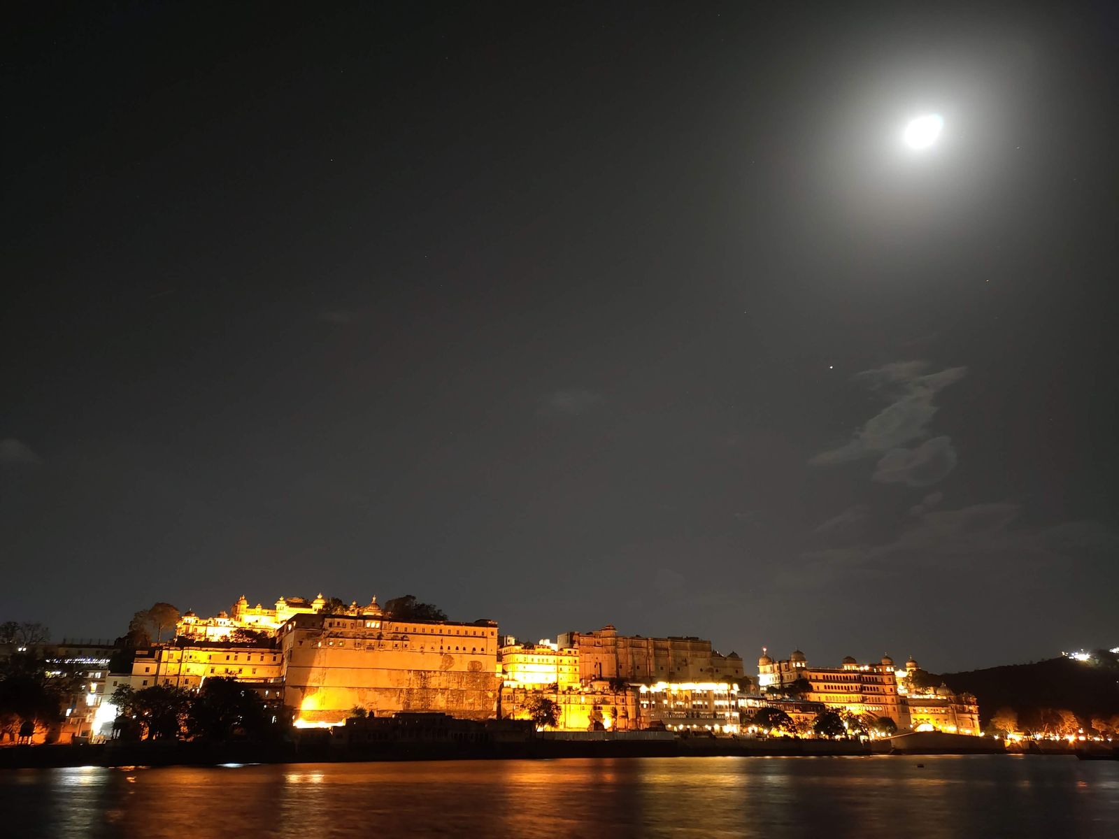 Evening crowds and lights along Ambrai Ghat in Udaipur, facing Lake Pichola