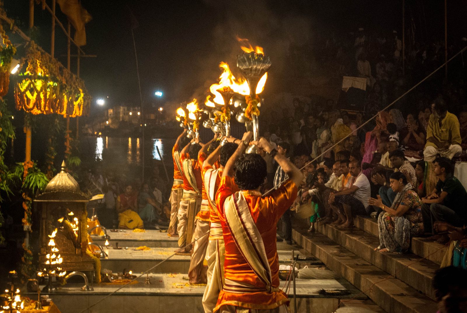 Priests raising brass lamps during the evening Ganga aarti at Dashashwamedh Ghat in Varanasi